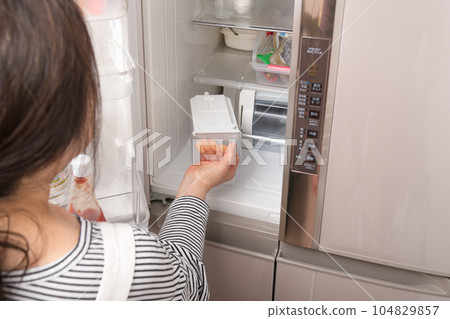 [Housewife taking out the water tank from the refrigerator] 104829857