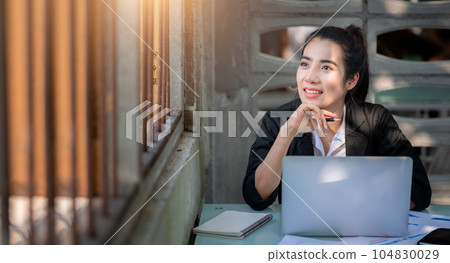 Busy young business woman working in coffee shop 104830029
