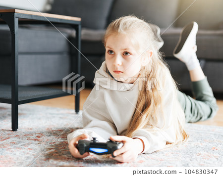 Girl playing video game at home 104830347