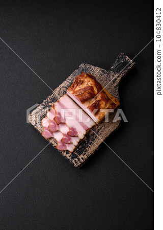 Delicious calorie smoked bacon with salt, spices and herbs Delicious calorie smoked bacon with salt, spices and herbs 104830412