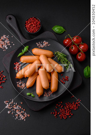 Delicious fresh boiled sausages with salt, spices and herbs 104830452