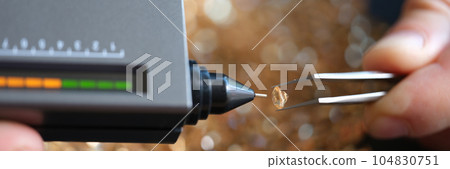 Many diamonds, tweezers and diamond testing machine close up. Many diamonds, tweezers and diamond testing machine close up. 104830751