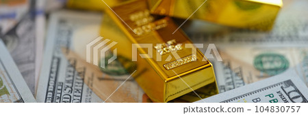 Gold bars on US dollar banknotes background. 104830757