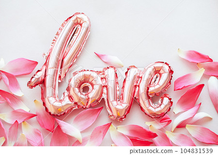Flowery petals and word Love from foil balloon, creative layout. 104831539