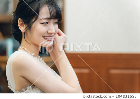 新娘和戴著耳環和新娘珠寶的新娘準備婚禮、儀式和招待會 新娘和戴著耳環和新娘珠寶的新娘準備婚禮、儀式和招待會 104831655