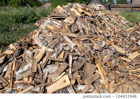 A large pile of different sawn firewood for the stove. Preparing firewood for the winter. Firewood background. A large pile of different sawn firewood for the stove. Preparing firewood for the winter. Firewood background. 104831946