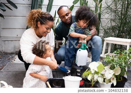 African American Family with two children Bonding in the Garden and Planting and Growing Together 104832138
