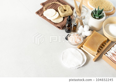 Natural bathroom and home spa tools. Zero waste sustainable lifestyle concept. Bamboo toothbrush, natural soap bar, cotton pads, homemade DIY beauty products in reusable bottles on white background 104832245