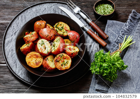 Herbs Garlic Potatoes in black bowl, top view 104832579
