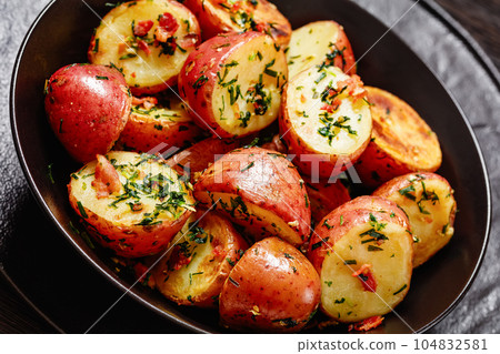 Herbs Garlic Potatoes in black bowl, top view Herbs Garlic Potatoes in black bowl, top view 104832581