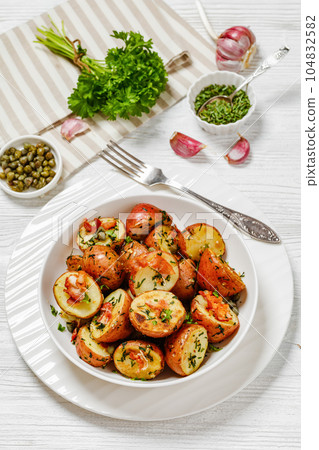Herbs Garlic Potatoes in white bowl, top view Herbs Garlic Potatoes in white bowl, top view 104832582