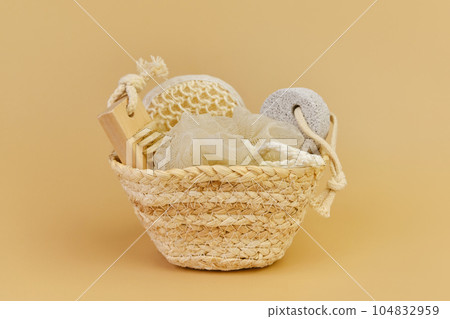 Bath accessories set in wicker basket on a beige background. Bath accessories set in wicker basket on a beige background. 104832959