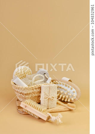 Bath accessories set in wicker basket on a beige background. 104832961