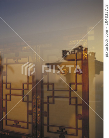 酒店大廳門的裝飾和玻璃上倒映的夕陽 酒店大廳門的裝飾和玻璃上倒映的夕陽 104833718