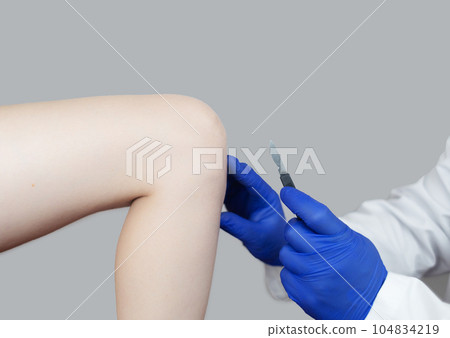 Knee surgery. Orthopedic surgeon shows patient where the incision will be made to repair the tendon, cartilage, and eliminate the effects of arthralgia. Concept of providing qualified care to patients 104834219