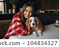 Cheerful woman hugging her beloved pet dog at home . Generative AI 104834327
