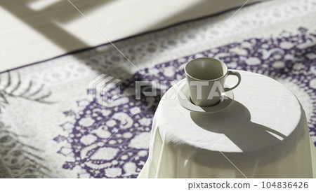 This room has a calm atmosphere with natural light. There are clay pots, glass bottles, coffee and various objects on the table. 104836426