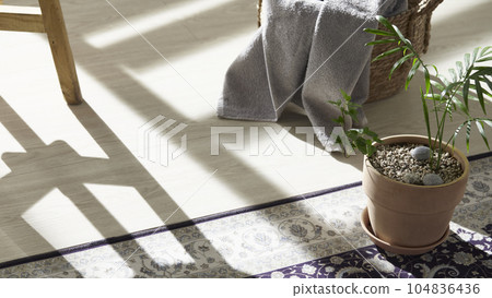 This room has a calm atmosphere with natural light. There are clay pots, glass bottles, coffee and various objects on the table. 104836436