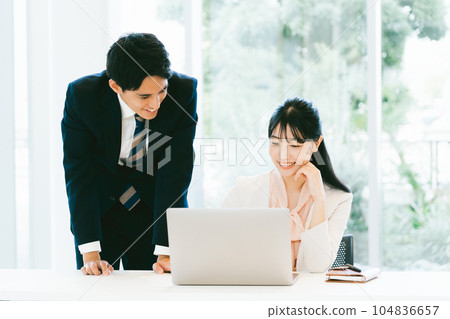 Male and female office workers working in a bright office Male and female office workers working in a bright office 104836657