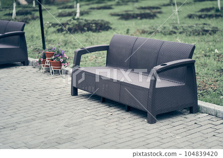 Plastic wicker garden furniture. A bench made of woven plastic. Lightweight portable garden furniture for a country house, terraces. High quality photo 104839420