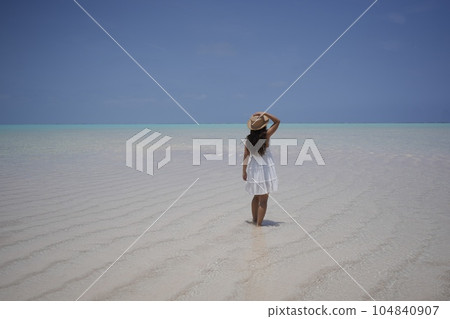 A woman walking along the lily beach on Yoron Island A woman walking along the lily beach on Yoron Island 104840907