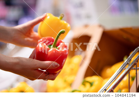 Woman's hand picking paprika 104841194