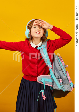 Happy schoolgirl with backpack, headphone having fun Happy schoolgirl with backpack, headphone having fun 104841569