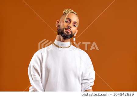Black latin gay man isolated on orange background Black latin gay man isolated on orange background 104842689