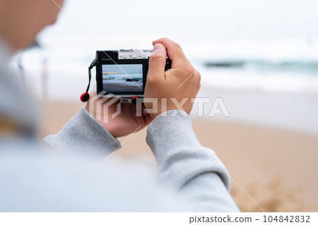 Traveller make photo holding mirrorless camera in hand Traveller make photo holding mirrorless camera in hand 104842832