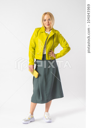 A young blonde woman in a stylish casual outfit with a small leather clutch. A young blonde woman in a stylish casual outfit with a small leather clutch. 104843969