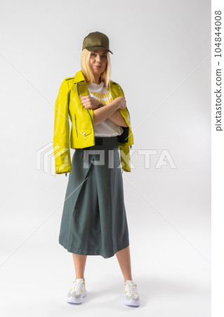 A woman in fashionable casual wear threw a leather jacket over her shoulders. 104844008