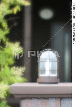 Gate light on brick fence 104844090