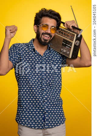 Indian man using retro tape record player to listen music disco dancing of favorite track having fun Indian man using retro tape record player to listen music disco dancing of favorite track having fun 104845105
