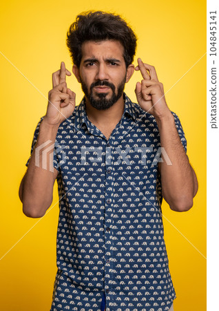 Indian man crossed fingers asking good luck, wishing good exam results, win victory lottery jackpot 104845141
