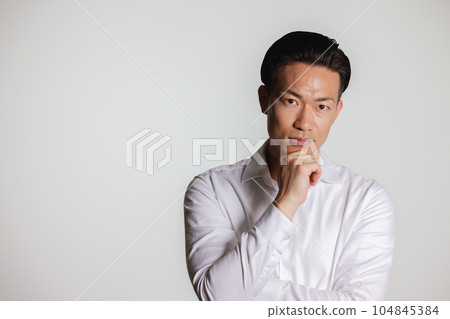 一個男人在他的下巴上打他的手 一個男人在他的下巴上打他的手 104845384