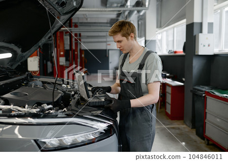 Mechanic providing computer diagnostics to find cause of car failure Mechanic providing computer diagnostics to find cause of car failure 104846011