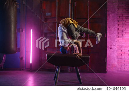 Male hip hop dancer on head stand doing acrobatic stunt 104846103