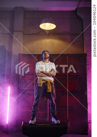 Fashionable b-boy breakdancer posing for camera standing on steel barrel tank 104846124