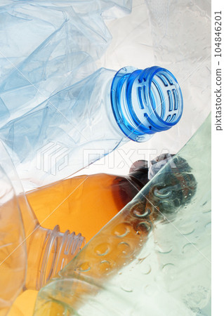 Transparent plastic bottle crumpled plastic recycling waste sorting. Pile of bottles PET recycling bottles background. Crushed bottle smashed plastic background. Recyclable materials. Disposable. Used 104846201