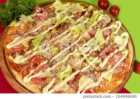 Pizza with bacon cheese and herbs on a wooden plate with cheese and cherry tomatoes. On a colored Pizza with bacon cheese and herbs on a wooden plate with cheese and cherry tomatoes. On a colored 104846690