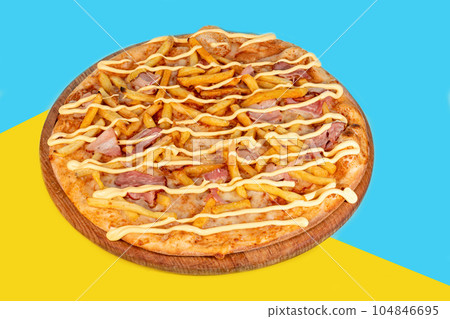 Pizza with bacon cheese and herbs on a wooden plate with cheese and cherry tomatoes. On a colored Pizza with bacon cheese and herbs on a wooden plate with cheese and cherry tomatoes. On a colored 104846695