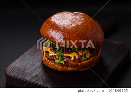 Burger with juicy beef cutlet, cheese, tomatoes, salt, spices and herbs Burger with juicy beef cutlet, cheese, tomatoes, salt, spices and herbs 104849365