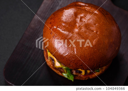 Burger with juicy beef cutlet, cheese, tomatoes, salt, spices and herbs 104849366