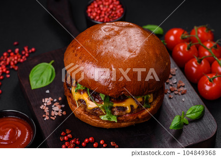 Burger with juicy beef cutlet, cheese, tomatoes, salt, spices and herbs 104849368