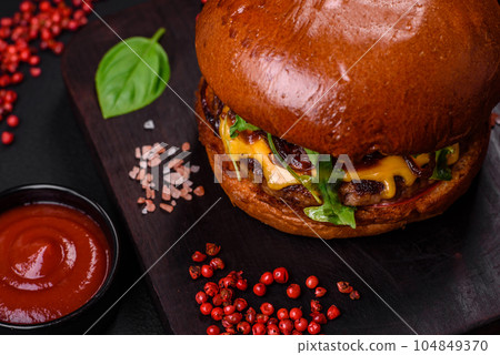 Burger with juicy beef cutlet, cheese, tomatoes, salt, spices and herbs 104849370
