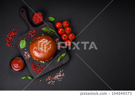 Burger with juicy beef cutlet, cheese, tomatoes, salt, spices and herbs 104849373