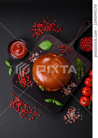 Burger with juicy beef cutlet, cheese, tomatoes, salt, spices and herbs 104849379