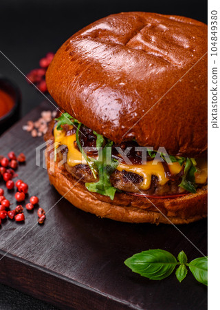 Burger with juicy beef cutlet, cheese, tomatoes, salt, spices and herbs 104849380
