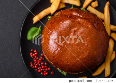 Burger with juicy beef cutlet, cheese, tomatoes, salt, spices and herbs Burger with juicy beef cutlet, cheese, tomatoes, salt, spices and herbs 104849426