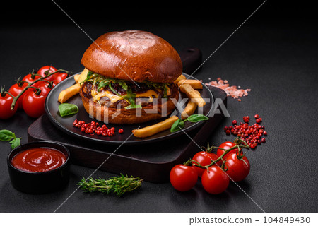 Burger with juicy beef cutlet, cheese, tomatoes, salt, spices and herbs 104849430